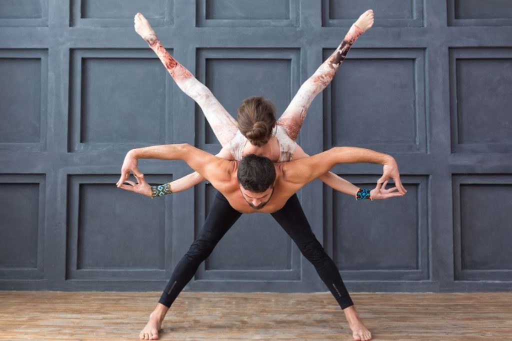 Two young women practicing balance acro yoga pose (637787)